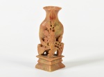Escultura oriental em pedra polida, representando vaso com flores. Altura: 11cm.