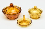 Lote composto de peças de toucador, em vidro de tonalidade âmbar. Apresenta bicado. Altura e diâmetro: 10 x 12,5cm / 8 x 9,5cm / 7 x 9cm.