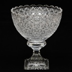 Fruteira em cristal translúcido, possivelmente Baccarat, decorado com rica lapidação estrela. Possui leve bicado na borda. Altura e diâmetro: 28 x 24cm.