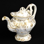Bule para chá em porcelana esmaltada e vitrificada na cor branca, decorada com realces dourados. Altura: 20,5cm.