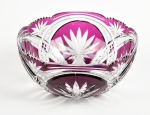 BACCARAT - Centro de mesa em cristal double na cor violeta, ricamente lapidado com palmas e estrelas. Apresenta eves bicados nas bordas. Altura e diâmetro: 10,5 x 22,5cm.