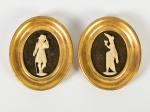Par de pequenos quadros decorativos ovais representando DAMA/CAVALEIRO em marfim sobre fundo escuro e emoldurados em madeira dourada. Med: 10cm