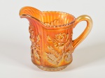 Jarro em carnival glass na tonalidade âmbar, decorada com motivos florais. Altura: 12,5cm.