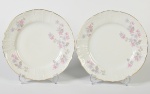 BERNADOTTE - Par de pratos rasos em porcelana europeia esmaltada e vitrificada, com decoração floral e fio dourado nas bordas. Diâmetro: 24,5cm.