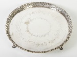 Grande salva em metal espessurado a prata, laterais vazadas e cinzeladas com motivos florais. Apresenta leve s=desnível em 1 dos pés. Altura e diâmetro: 6,5 x 45cm.