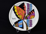 GERMER - Prato para bolo em porcelana esmaltada e vitrificada na cor branca, decorada com reprodução de oba do artista brasileiro KENNEDY BAHIA. Diâmetro: 28cm.