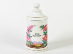 Pote de farmácia em porcelana esmaltada e vitrificada na cor branca, com decoração floral pintada à mão. Assinado na base. Altura: 26cm.