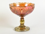 Compoteira em carnival glass na tonalidade âmbar, decorada com lapidação em relevo. Falta a tampa. Altura e diâmetro: 16,5 x 16,5cm.