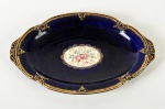 SACAVEM - Travessa em faiança portuguesa esmaltada e vitrificada, na cor azul escuro, decorada com motivos florais e realces dourados nas bordas. Medidas: 2,5 x 23,5 x 15,5cm.