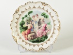 REAL - Prato decorativo em porcelana esmaltada e vitrificada, decorado com damas e realces dourados. Diâmetro: 20cm.