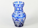 Vaso em cristal doublé na cor azul, decorado com lapidações em folhagens e estrelas. Apresenta 2 pequenos bicados na base. Altura: 23cm.