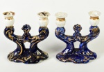 Par de candelabros para 2 velas, em porcelana na cor azul, com realces dourados. 1 candelabro apresenta fios de cabelo nos encaixes para vela. Medidas: 15 x 14 x 8cm.