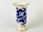 ZAPPI - Vaso em faiança esmaltada e vitrificada, decorado com motivos florais e realces dourados. Apresenta fio de cabelo na borda. Altura: 31cm.