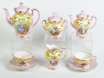 Serviço tete a tete em porcelana esmaltada e vitrificada na cor rosa, decorado com motivos florais e cena galante. Composto por 1 bule para chá, 1 bule para café (apresenta leve bicado na ponta), 1 açucareiro, 1 leiteira e 2 xícaras para chá. Total de 6 peças.