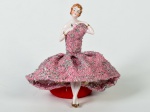 Boneca em porcelana esmaltada e vitrificada, saia em tecido na cor rosa. Altura: 13,5cm.