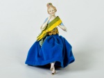 Boneca em porcelana esmaltada e vitrificada, saia em tecido na cor azul. Altura: 14,5cm.
