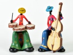 Par de esculturas em resina, representando músicos populares (baixista e baterista). Baixista se encontra com restauros e dedo quebrado. Altura: 15,5 x 13cm.