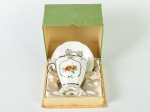 MAUÁ - Xícara para chá e pires em porcelana esmaltada e vitrificada na cor branca, decoração floral e realces dourados. Acondicionado em caixa na cor verde.