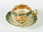 Xícara para chá em porcelana esmaltada e vitrificada na cor verde, com decoração floral dourada em relevo. Altura da xícara: 7cm.