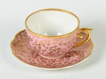 MAUÁ - Xícara para café e pires, em porcelana esmaltada e vitrificada em porcelana na cor rosa com motivos florais dourados. Altura da xícara: 4cm.