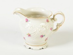 KPM - Leiteira em porcelana polonesa esmaltada e vitrificada na cor branca, decorada com motivos florais e fio dourado nas bordas. Altura: 8,5cm.