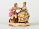 Antiga escultura em porcelana alemã, representando casal de época. Apresenta leve bicado na base. Medidas: 11,5 x 11 x 5cm.