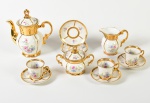 REAL - Serviço para café em porcelana esmaltada e vitrificada com decoração floral e realces dourados. Composto por 1 bule, 1 leiteira, 1 açucareiro e 3 xícaras com pires (1 xícara possui bicado na borda). Total de 6 peças.