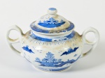 Açucareiro em porcelana oriental esmaltada e vitrificada na cor branca, decorado com cenas de paisagem e pagodes. Necessita de limpeza. Altura: 12,5cm.