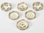 Conjunto de 6 suportes para copos em metal e faiança, com decoração floral. Altura e diâmetro: 2 x 7cm.