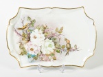 Travessa em porcelana esmaltada e vitrificada com decoração floral pintada a mão e fio dourado nas bordas. Medidas: 34,5 x 23,5cm.
