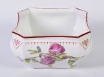 Centro de mesa em porcelana esmaltada e vitrificada na cor branca, decorado com motivos florais. Apresenta fio de cabelo na base. Medidas: 12 x 21 x 21cm.