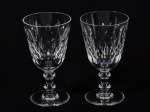 BACCARAT - Par de taças para vinho em cristal translúcido, com fina lapidação de losangos em relevo. Altura: 12cm.