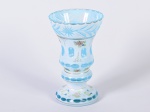 Vaso em cristal overlay na cor branco opalinado e azul, decorado com motivos florais e lapidação em gomos, estrelas e ramos. Possui discreto bicado na borda. Altura: 20cm.