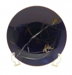 Centro de mesa circular em porcelana oriental na cor azul cobalto; adornado com motivos florais e vegetalistas e filete dourado na borda. Medidas: 28 x 5,5 cm. Com sinais de restauro.