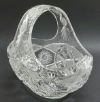 Cesta oval em robusto cristal translúcido, lapidado com caneluras, elementos losangulares e estelares. Medidas: 31 x 28 cm.