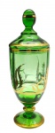 Bomboniere em cristal translúcido verde, adornada com filetes, faixas e padrões fitomórficos em dourado; base tipo pedestal. Medidas: 32 x 11 cm. Douração ligeiramente desvanecida em alguns pontos.
