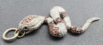 PINGENTE DE PRATA, 10g - COBRA - Antigo pingente em forma de cobra, pesando por inteiro 10g. Cobra em prata com pequenas pedras vermelhas e translúcidas cravejadas. Medida: 6cm aproximadamente.