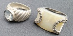ANÉIS DE PRATA, 23g - Lote com 2 anéis de prata, pesando juntos 23g. Design rústico, tendo um com marcassita no topo em formato quadrangular e circundado em 2 laterais com pequenas pedras translúcidas, medindo 2,5cm de diâmetro. O outro anel com pequena pedra ao centro em tom azul, textura ondulada, medindo 2,5cm.