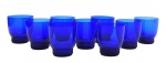 09 copos em vidro na cor azul cobalto, decorados na base com detalhes esféricos em relevo. Medidas: 8 x 7,5 cm. Com ínfimos bicados na borda.