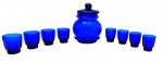 01 bomboniere e 08 copos em vidro na cor azul cobalto, decorados na base com detalhes esféricos em relevo. Medidas: 19 x 13 cm (bomboniere); 6,5 x 5,5 cm (copos). Com ínfimos bicados na borda.