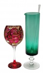 01 taça misturadora para coquetéis com bastão de vidro, em vidro verde e incolor, e base pedestal; e 01 taça pé alto em vidro, adornada com padrões florais na cor rosa com detalhes em dourado. Medidas: 29 x 8 cm; 20 x 9 cm. Taça misturadora com arranhões na borda.