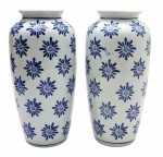 Par de vasos decorados com padrões florais em azul cobalto; em porcelana no formato ovalado. Medidas: 25 x 11 cm.