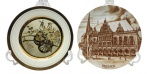 02 pratos decorativos, sendo um em porcelana japonesa, adornado em ouro 24 k com faixas, filetes e uma carroça com flores; e o outro em porcelana alemã, souvenir da cidade de Bremen, na Alemanha, e estampado com o prédio da prefeitura da cidade. Medidas: 23,5 cm (diâm.); 24 cm (diâm.).