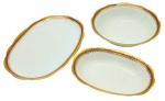 PORCELANA RENNER, PORTO ALEGRE - Parte de serviço de jantar com 01 bowl oval, 01 bowl redondo e 01 travessa oval; decorados com faixa na cor vinho, e arabescos e motivos vegetalistas em dourado. Em porcelana. Medidas: 24 x 4 cm; 24 x 5 cm; 32 x 22 cm.