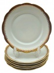 PORCELANA RENNER, PORTO ALEGRE - Parte de serviço de jantar com 06 pratos rasos decorados com faixa na cor vinho, e arabescos e motivos vegetalistas em dourado. Em porcelana. Medidas: 24 cm (diâm.).