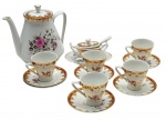 PORCELANA SCHMIDT - Parte de serviço de café composto por 01 bule, 01 açucareiro com presentoir integrado, 05 xícaras de café e 06 pires para xícaras de café; decorados com faixas na cor vinho, arabescos e motivos vegetalistas em dourado e colorido buquê floral. Em porcelana. Medidas: 18 x 17 cm; 8,5 x 6,5 cm. Açucareiro com fios de cabelo.