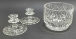 01 cachepot circular e 02 castiçais em cristal translúcido, com diferentes padrões decorativos, sendo o cachepot com detalhes canelados, caneluras elípticas e geométricos; e os castiçais gravados na base com motivos florais. Medidas: 15 x 11,5 cm; 11,5 x 7,5 cm.