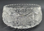 Centro de mesa circular em robusto cristal translúcido, lapidado com borda serrilhada, elementos geométricos e caneluras. Medidas: 21 x 9 cm.