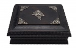 Porta-jóias em madeira nobre ricamente entalhada com detalhes ondulados na tampa e nas laterais; tampa com apliques de prata trabalhados com motivos florais. Tampa articulada. Medidas: 20 x 16 x 8 cm.