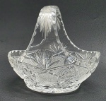 Cesta oval em robusto cristal translúcido, lapidado com caneluras, elementos losangulares, fitomórficos e estelares. Medidas: 18 x 16 x 14 cm.